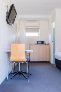 an empty room with a table and a chair at Kite Street Units in Orange