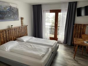 sypialnia z dwoma łóżkami i oknem w obiekcie La Irmania Pension w mieście Ledenitzen