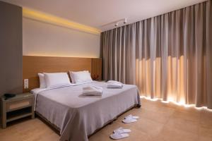 a bedroom with a bed with white towels on it at Olympion Sunset Halkidiki in Fourka