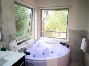 a large white tub in a bathroom with two windows at Merry Mary in Marysville