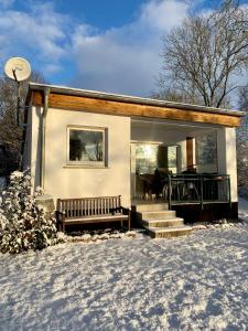 ein kleines Haus mit einer Bank im Schnee in der Unterkunft Ferienhaus am Schweriner See in Hohen Viecheln