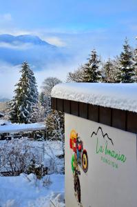 a sign in the snow with a mountain on it at La Irmania Pension in Ledenitzen