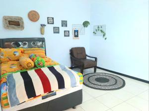 1 dormitorio con 1 cama y 1 silla en Villa Fifari - 5 Kamar Tidur, 3 Kamar Mandi, en Batu