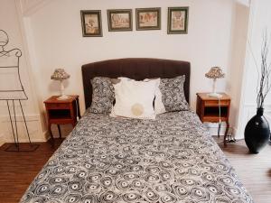 ein Schlafzimmer mit einem Bett mit Kissen und 2 Tischen in der Unterkunft Les Clefs de la Liberté in Colmar