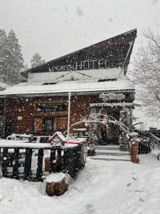 un bâtiment recouvert de neige devant dans l'établissement Hôtel Green Ecolodge, à La Colmiane