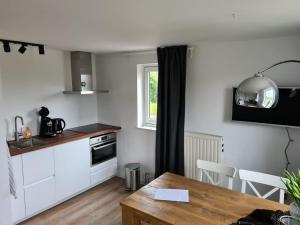 a kitchen and dining room with a table and a window at Hoeve Zandbelt in Markelo