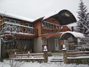 Una casa en la nieve con balcón en U dida Grytsya, en Yaremche