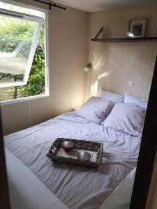 - un plateau de nourriture sur un lit avec une fenêtre dans l'établissement Camping La Dune Blanche - Daly's home, à Camiers