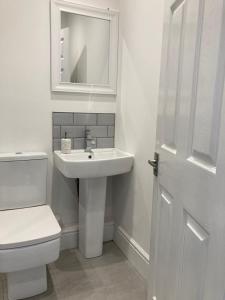 a bathroom with a sink and a toilet and a mirror at Ouse View Cottage in Goole