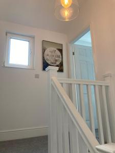 a white staircase with a glass door and a window at Ouse View Cottage in Goole