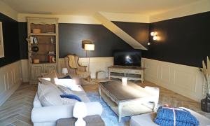 a living room with a couch and a tv at Maison d'hôtes La Bella Casa in Villette-dʼAnthon
