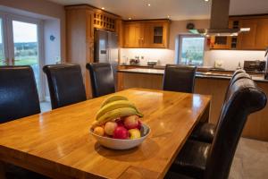 a bowl of fruit on a wooden table in a kitchen at Kentraw Farmhouse Luxury Self Catering in Bruichladdich