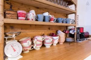 a bunch of coffee cups and a clock on a shelf at Le Hameau de Chantemerle in Samoëns
