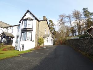 una calle vacía frente a una casa blanca en Great location, quiet yet 5 mins to Bowness centre with walks from the door and parking, en Bowness-on-Windermere