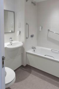 ein Badezimmer mit einem Waschbecken, einer Badewanne und einem WC in der Unterkunft Kings Highway, Derby by Marston's Inns in Derby