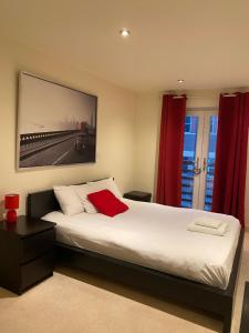 a bedroom with a large bed with red curtains at The Sawmill in Hull