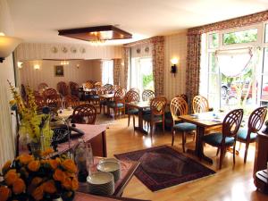 a dining room with wooden tables and chairs and a dining room at Hotel Zur Fischerklause in Fedderwardersiel