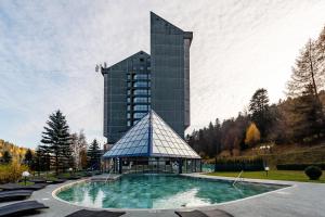 a building with a swimming pool in front of a building at Hotel Mara in Sinaia