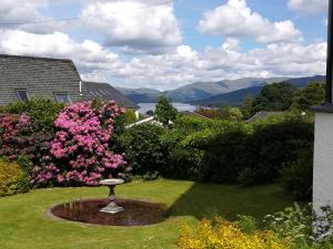 un jardín con un baño de aves en el césped en Great location, quiet yet 5 mins to Bowness centre with walks from the door and parking, en Bowness-on-Windermere