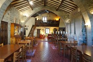 ein Restaurant mit Holztischen und -stühlen und einer Treppe in der Unterkunft La Sala de Camós in Camós