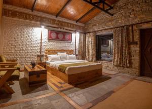a bedroom with a bed and a brick wall at BluSalzz Homes - The Himalayan Bungalow, Almora - Uttarakhand in Almora