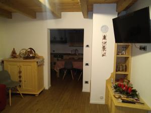 a living room with a television and a dining room at Greuth Hutte in Tarvisio