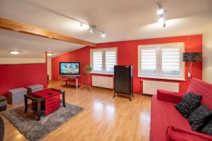 a living room with red walls and a red couch at Apartament LUIZA in Lądek-Zdrój