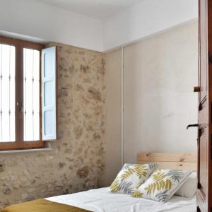 a bedroom with a bed and a window at Villa Serrano La casa rural de los mil suelos in Valencia