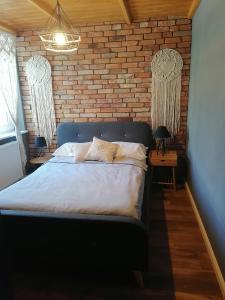 1 dormitorio con cama y pared de ladrillo en Apartament Jeleń, en Złotów