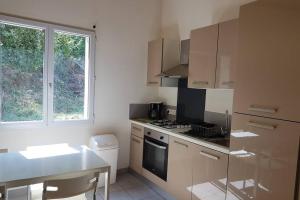 een kleine keuken met een fornuis en een raam bij Gite Le Maty in Saint-André-Capcèze