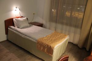 a bedroom with a bed with a lamp on it at Hotelli Patruuna in Imatra