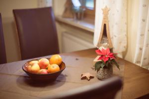 eine Schale Obst auf einem Tisch mit einer Vase Blumen in der Unterkunft Haus Gstatter in Ruhpolding