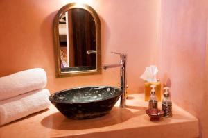 a bathroom with a sink with a mirror and a sink at Dar Sofar in Agdz