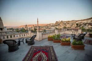 a balcony with chairs and a view of a city at Stone House Cave Hotel in Göreme