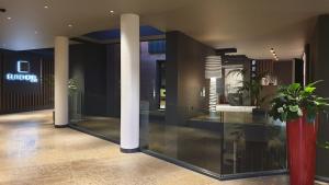 a lobby with columns and plants in a building at Elite Hotel & Spa in Mestre