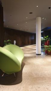 a green chair in a room with plants at Elite Hotel & Spa in Mestre