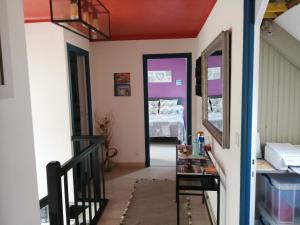 a hallway with a staircase and a room with a bed at GINGER in Cancale