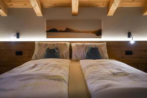 1 dormitorio con 2 camas y almohadas en Lüch de Crusteles en La Valle