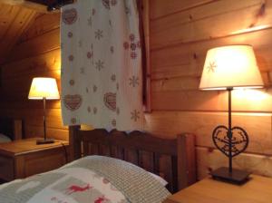 a bedroom with a bed and two lamps on tables at Chalets Savoie in Notre-Dame-de-Bellecombe