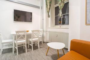 - un salon avec une table, des chaises et une télévision dans l'établissement Apartma N'Poznam Tobačna, à Ljubljana