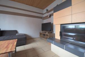 a small living room with a bed and a television at Ferienwohnung Haus Willi in Freinsheim