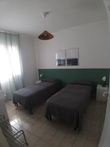 プンタ・セッカにあるCasa Danielaの緑の壁のベッドルーム1室(ベッド2台付)