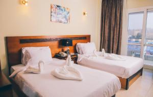 two beds in a hotel room with towels on them at Jewel Inn El Bakry Hotel in Cairo +73 photos