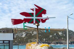 un poteau en bois avec un oiseau au au-dessus d'une roche dans l'établissement Casa da Vasca, à Malpica