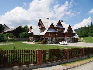 a large house with a fence in front of it at Dom Wczasowy Kazik in Maniowy +30 photos
