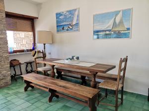 a dining room with a wooden table and benches at Villa Mimmi in Lido Di Fondi