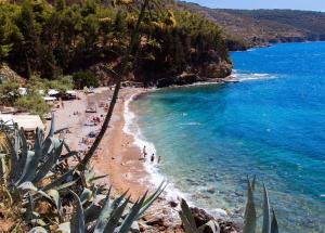 einen Strand mit Menschen auf dem Sand und blauem Wasser in der Unterkunft Apatmani Darija in Komiža