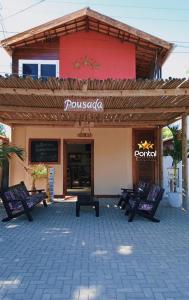 a restaurant with benches in front of a building at Pousada Pontal das Estrelas in Fortim