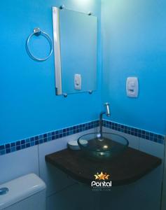 a bathroom with a sink with a mirror and a toilet at Pousada Pontal das Estrelas in Fortim