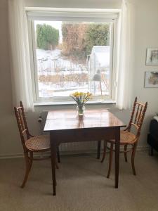 a dining room table with two chairs and a window at Kirkevængets mini Bed and Breakfast in Kruså